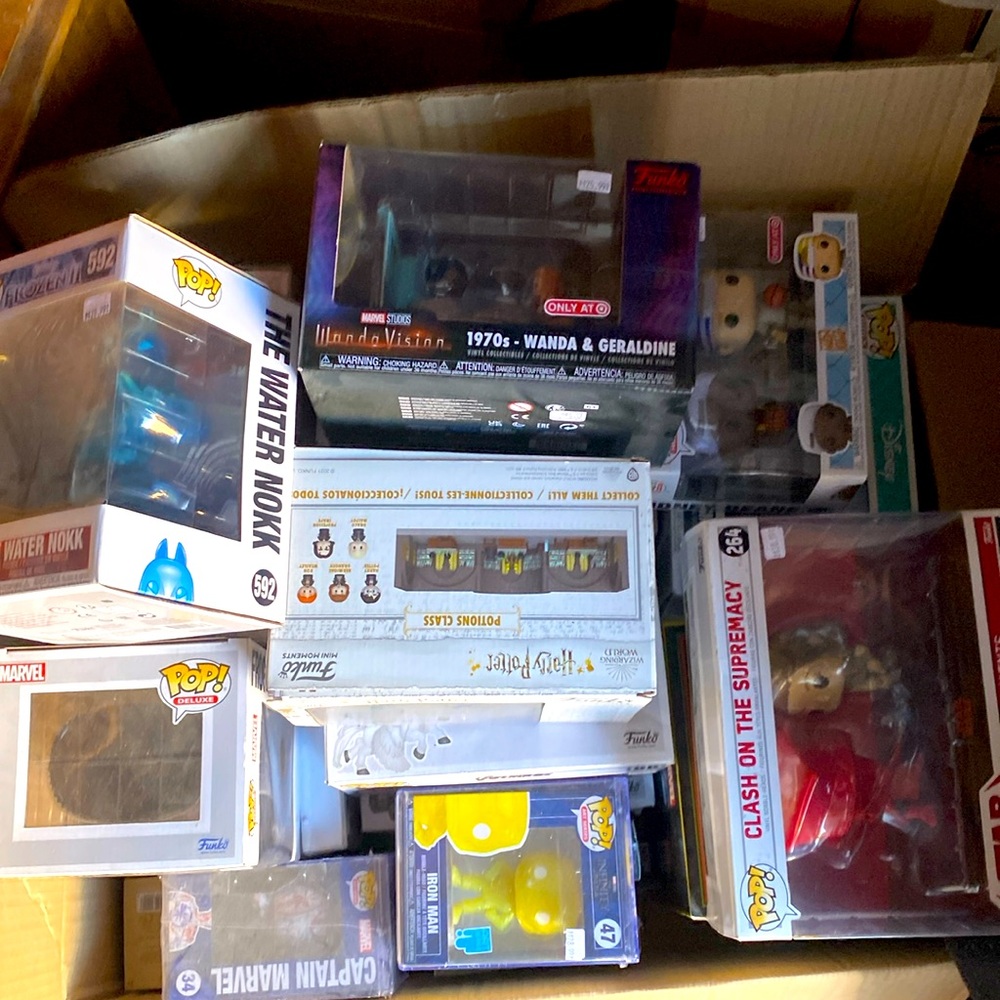 A box containing multiple Funko pops from Star Wars, marvel, and movies